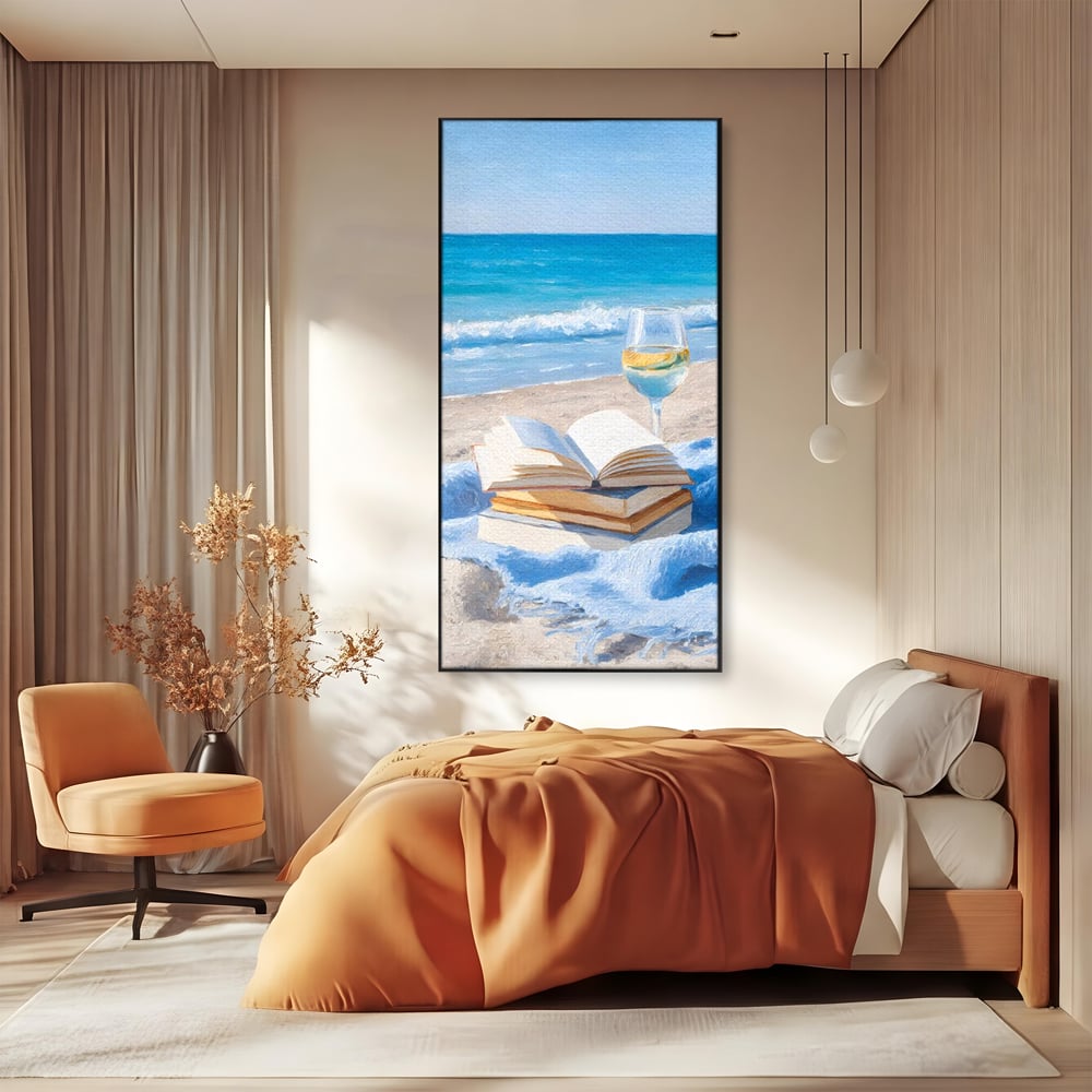 Tablou canvas cu pictura cu carti si pahar de vin pe plaja, in rama de aluminiu negru, pe perete intr-un dormitor